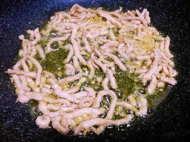 油烧八分热倒入肉丝快速滑散变色