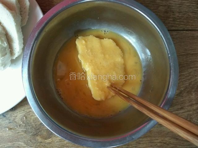 将馒头片放入鸡蛋液中裹匀。