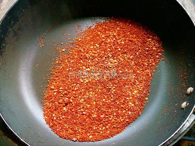 平底锅倒入适量辣椒粉，视个人吃辣程度加吧！不放油！小火煸炒出香味！
如果你的白芝麻是生的，就可以倒入和辣椒粉一起煸炒。