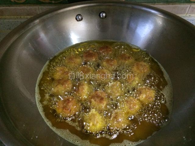 锅内倒入适量油油温6成可以炸丸子，左手一边将肉丸子搓圆一边下锅，我是袋一次性手套，把肉馅放在左手掌心，用虎口挤出，用一个勺子一戳刚好一个圆直接下锅