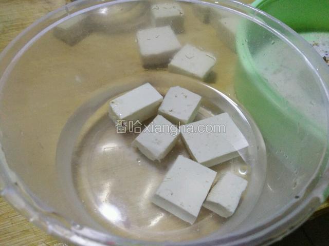 高度白酒倒入碗中，将发霉的豆腐放入白酒中沾一下迅速捞出裹盐料