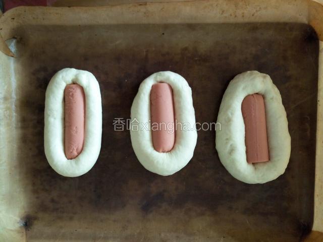 把火腿肠嵌在中间，自然发酵至两倍大