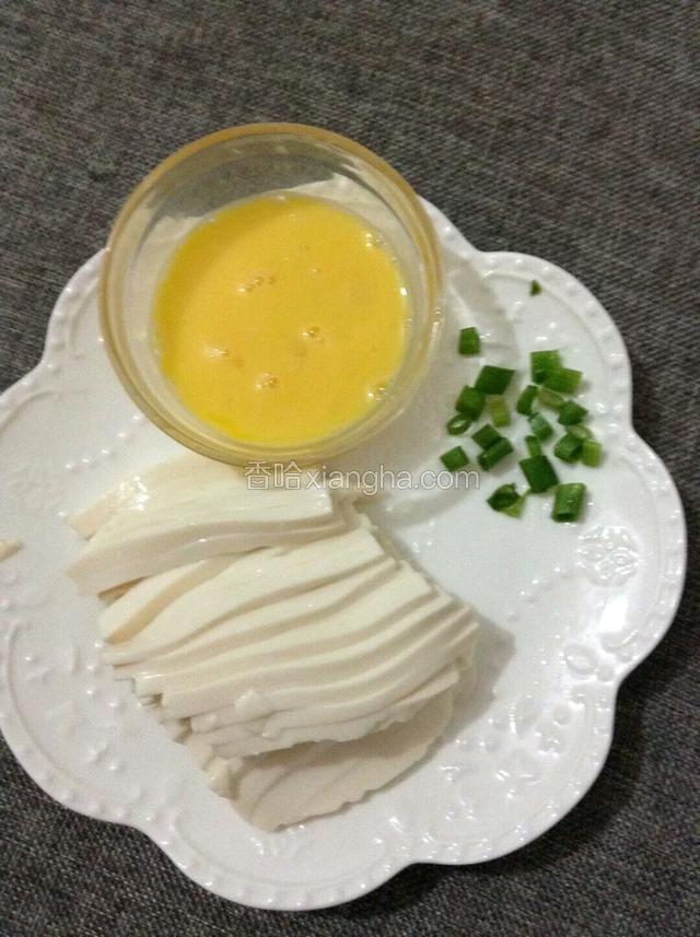 豆腐切成细条，鸡蛋磕入碗中打散，葱切末。