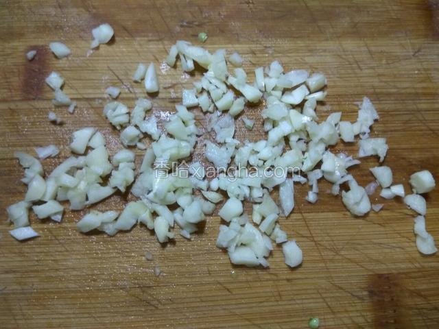 蒜瓣剥去外皮，用刀背拍碎，再切成碎末。