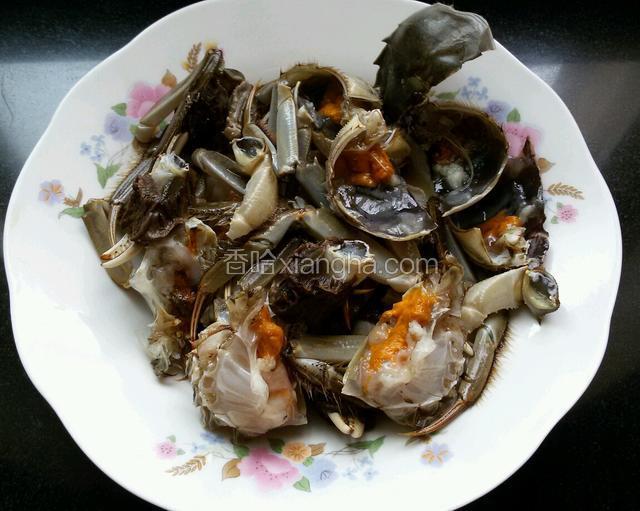 去蟹肺和蟹心，切两瓣倒料酒腌制半个小时。