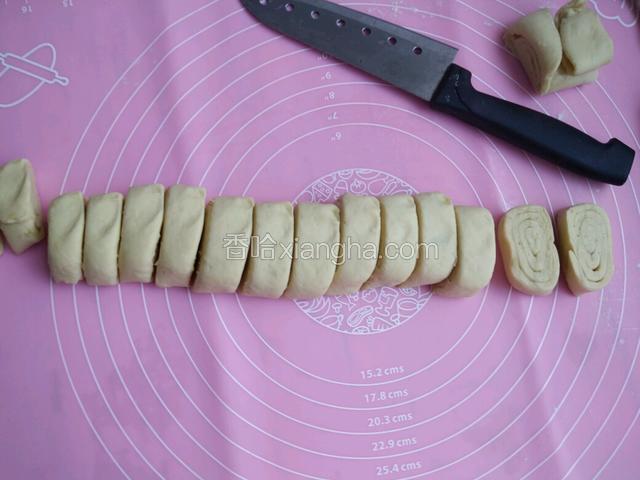 卷起后用手把长条两头切掉，然后稍微用手掌心按扁用刀切成图中的样子。