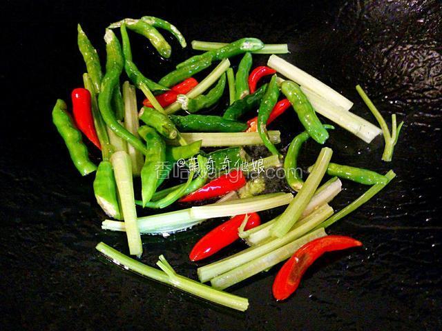 洗锅重新倒入少许油，下青辣椒，小米辣和芹菜段小火煸至辣椒呈虎皮状。