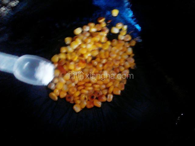 锅中加油放入蒜煸香后加入玉米粒并加入盐和糖