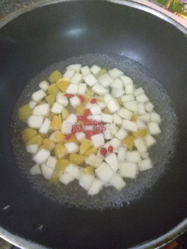 锅中注入清水烧开，下入苹果橙子和枸杞煮三分钟。
