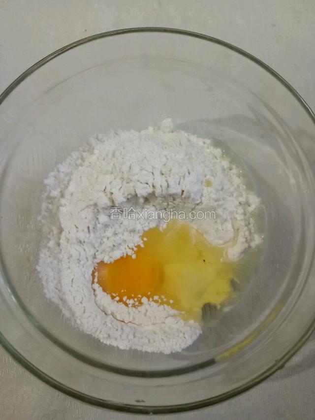 面粉放入碗中。磕入一个鸡蛋。