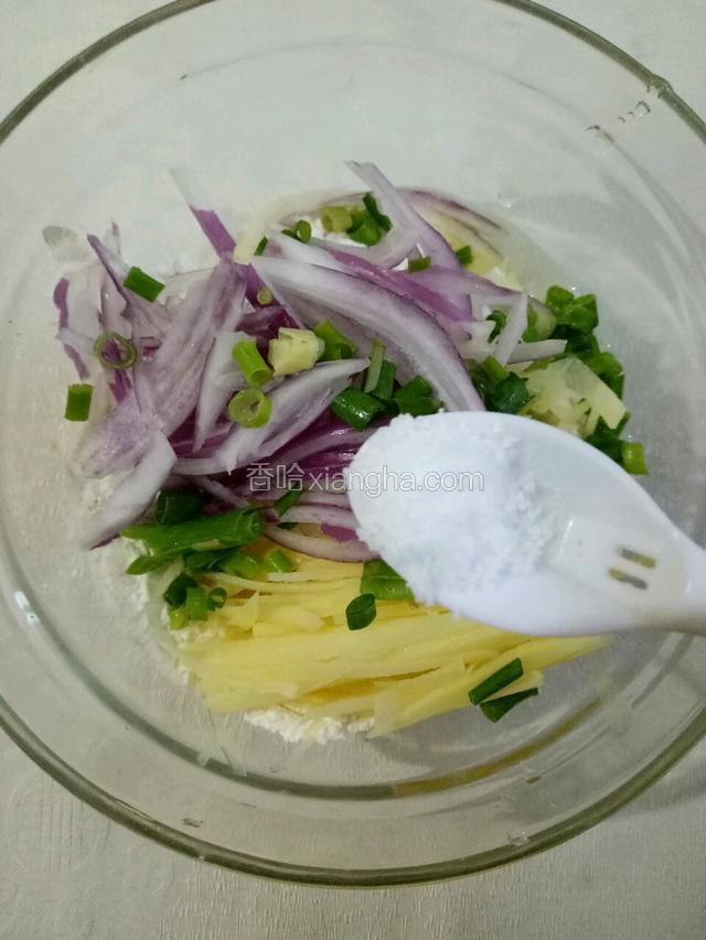 接着放入洋葱、土豆丝和葱花。加入少许盐和胡椒粉调味。