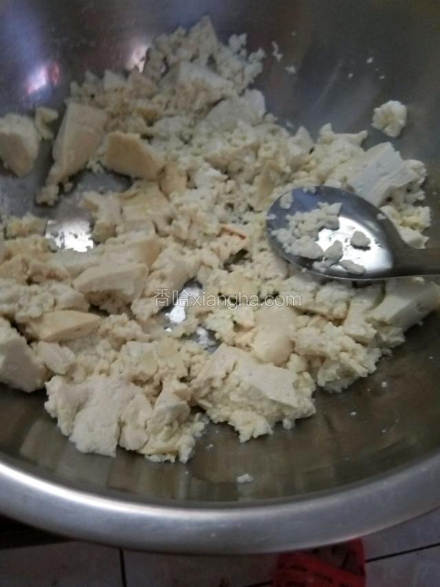 用小勺子或筷子把豆腐搅碎，把搅出来的水分倒掉