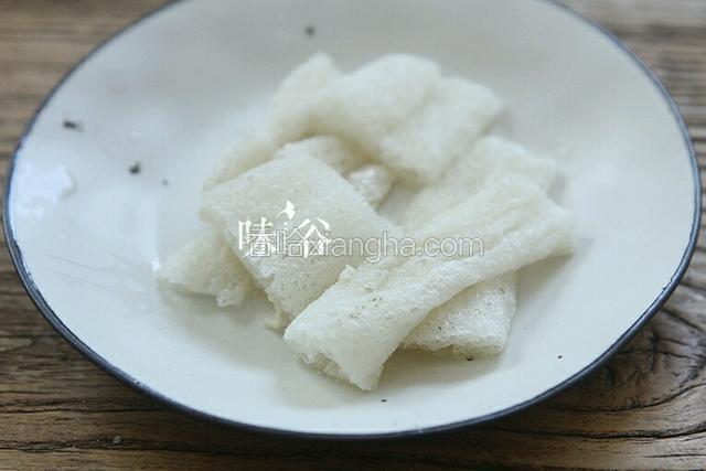 浸泡后的竹荪去根和头部，取中间部分切成段。