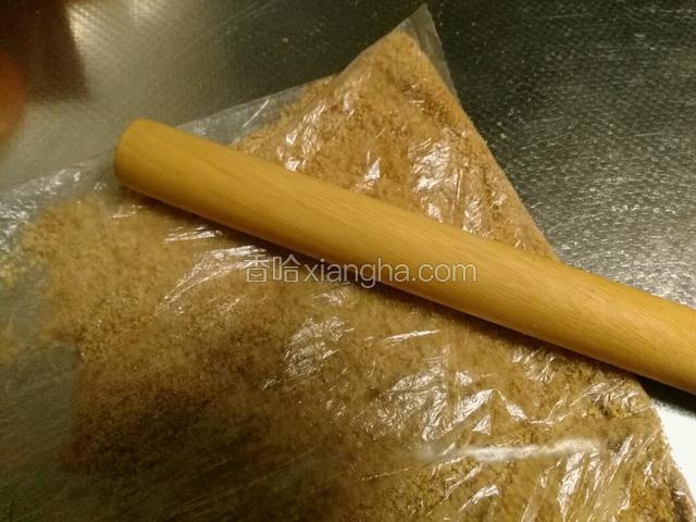 消化饼干用保鲜袋装起来，用擀面杖擀成碎末。
