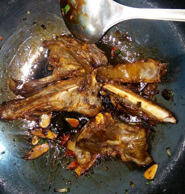放入焯好的羊骨快速炒匀，加入葱末，姜片，蒜片，老抽，生抽，花椒，八角，料酒炒至羊骨出油。