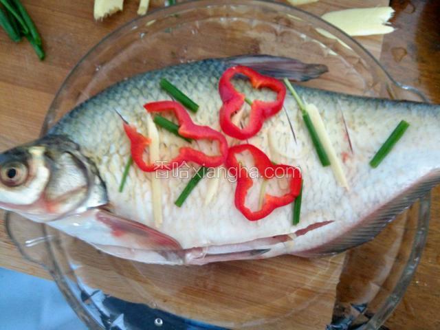 用盐，料酒，抹匀鱼，腌制15分钟，然后在碗底放姜片，放上鱼，鱼肚里也塞两片姜，上面铺点葱姜，红辣椒
