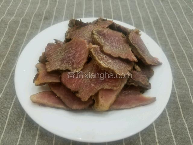 将煮好的腊肉切成片。