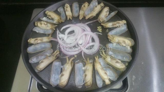 铁板放黄油，依次把蛏子排好，姜末撒在蛏子里，洋葱放中间