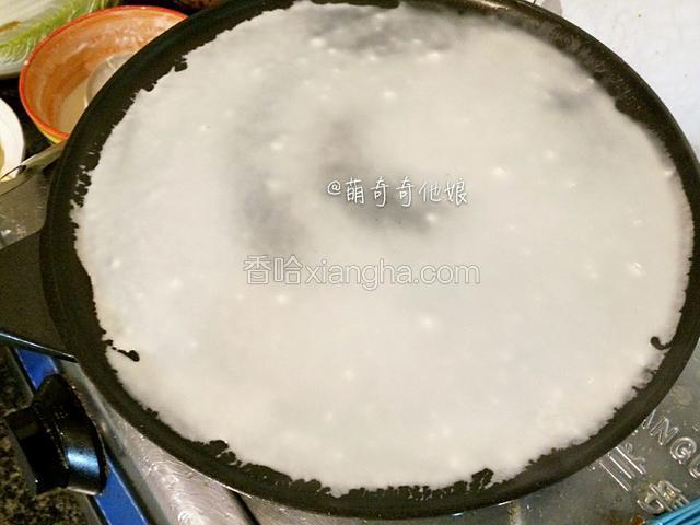 不粘平底锅不加热，先舀入一勺面糊晃动锅均匀铺开成薄圆形。
如果你的平底锅要粘，那就用硅胶刷刷一层薄薄的油后再倒面糊。