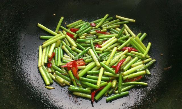 翻炒至蒜苔断生，少滴点生抽，放盐炒匀