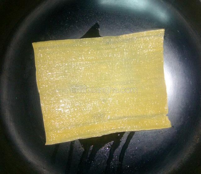 平底锅倒少许油，调小火，放入板冷面，再喷上少许水，使冷面变的稍软些。