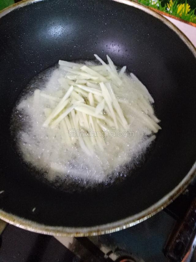 锅中注入食用油，烧至七成热，下土豆丝炸制。