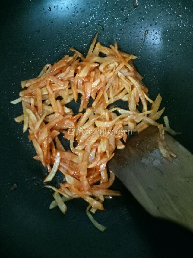 下土豆丝均匀的裹上番茄酱，撒上葱花即可出锅