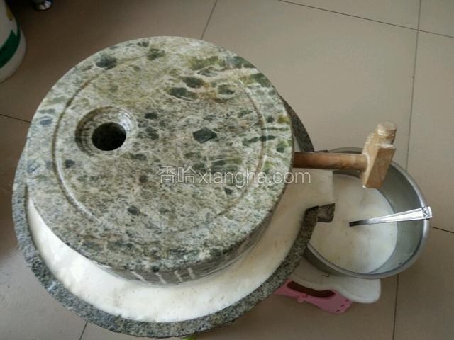黄豆放进小孔，顺时针转一圈，逆时针转5圈，加水再循环，看图中慢慢流出浆水和豆末