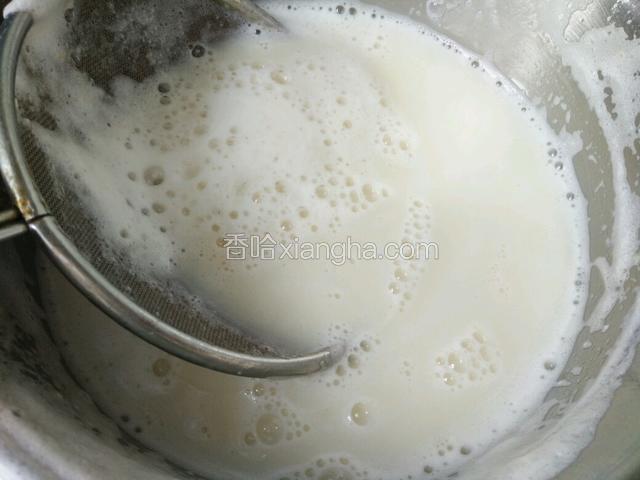 磨好的豆浆用漏勺虑去泡沫