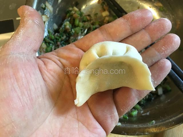 左右手配合把饺子皮捏紧，一个饺子生坯就捏好了。