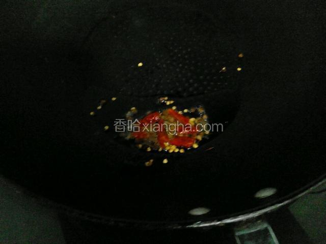 锅内放少许油，烧热后放入花椒粒和干辣椒炸出辣椒油