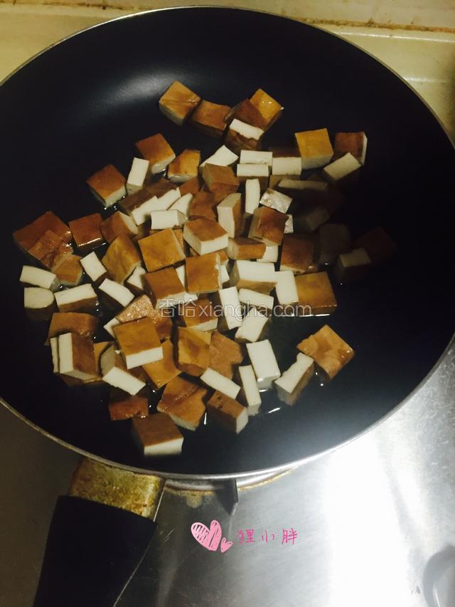锅内放少量油，小火炒制豆干