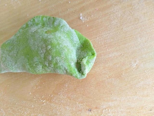 从右边开始，用拇指和食指将捏好的饺子边折上去，并轻轻的捏一下。