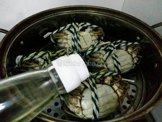 洗好的蟹反着放入蒸锅，在每个蟹上淋适量料酒