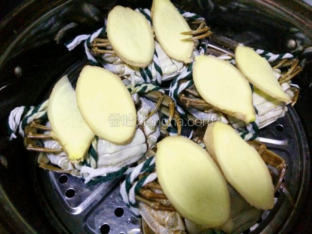 在每个蟹上放两片生姜，盖上锅盖大火蒸25分钟