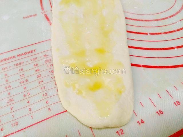 取一个面团擀长条，均匀滴抹上食用油。