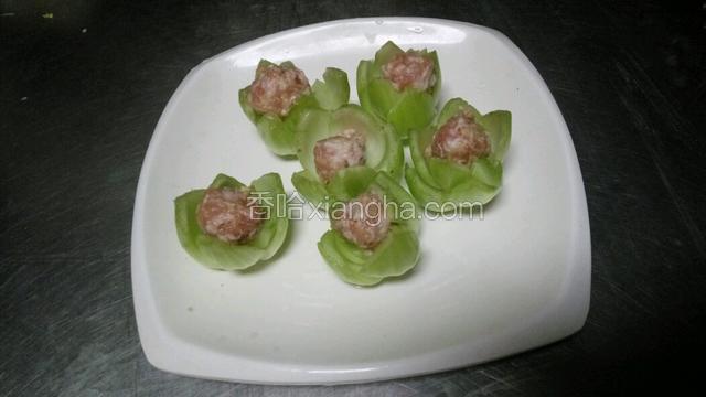 把挤好以后的丸子连同菜心一起放在盘中。