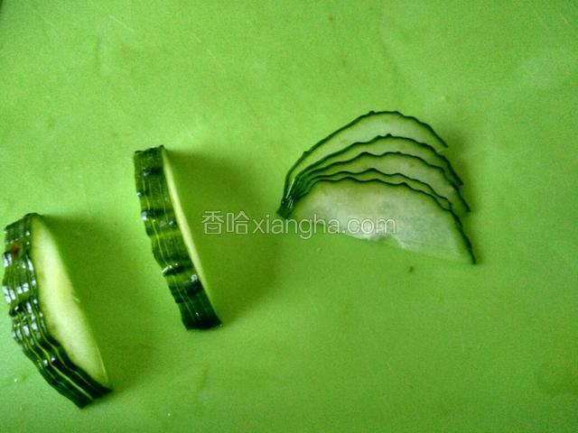 用直刀法将黄瓜切成梳子形(不要完全切断，一前端要留一点点)，每隔数片切一刀。用手将黄瓜推成扇形，当鱼的尾巴。切葱花当鱼泡泡。