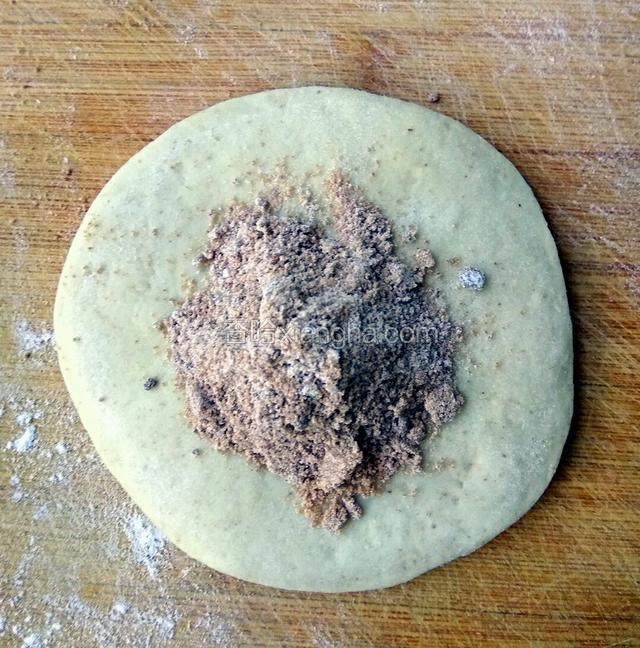 把剂子擀成饼，把糖馅儿放在饼的中间