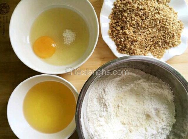 材料准备：低筋面粉里加泡打粉和小苏打，鸡蛋里加糖，还有准备好的玉米油和核桃碎