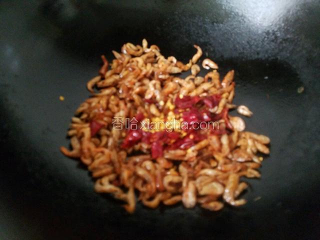 开大火将锅烧热，锅热后放入油，油五成热时放入虾米和干辣椒。将小河虾的水分炒干。因为小河虾在洗的过程中会有水分。
