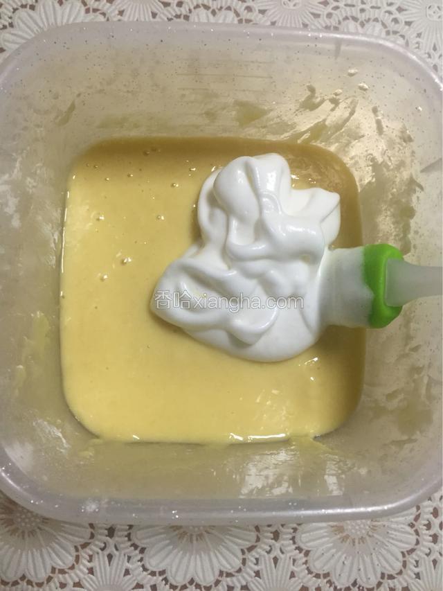 用橡皮刮刀取三分之一蛋白加入蛋黄盆中，轻轻翻拌