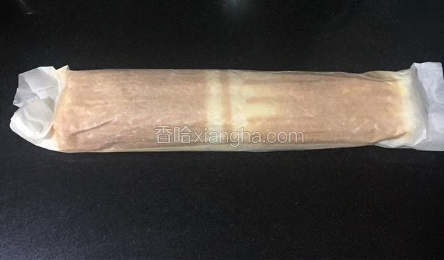 晾凉后的蛋糕放在油纸上，颜色深的那一面朝上，然后将其卷起成筒状，静置30分钟让其定型，也可放入冰箱冷藏，成型后取走油纸切件即可