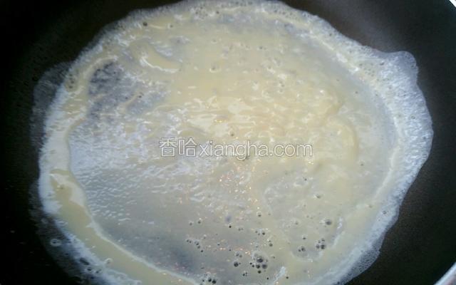 碗里打入鸡蛋加水打散搅拌均匀，锅里倒入少量油倒入蛋液，迅速晃动锅底把蛋液均匀的摊成薄薄蛋饼。