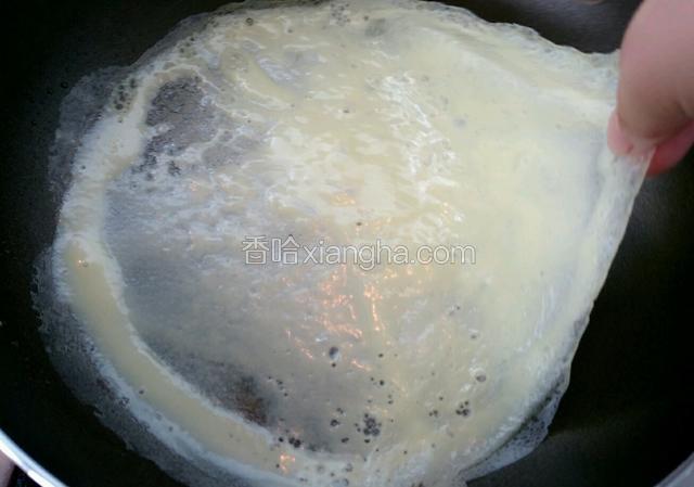 小火煎到蛋饼鼓起迅速翻面，然后倒入盘中。