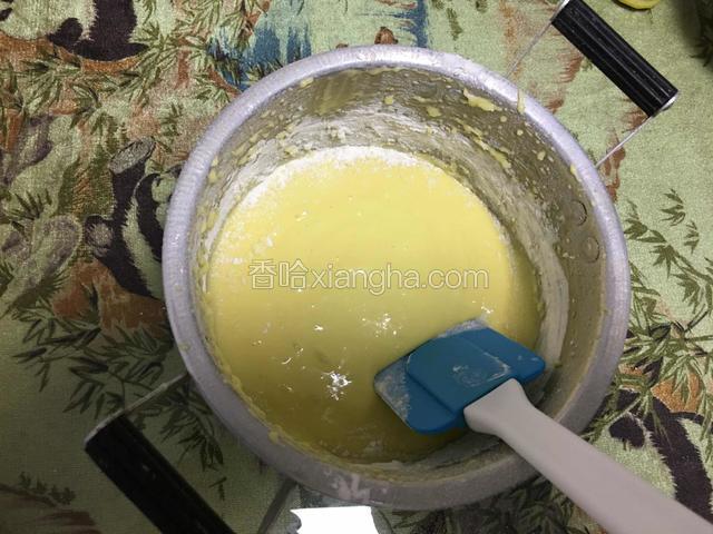 这是刚刚打好的蛋黄糊！用橡皮刮刀沿着四壁搞均匀！