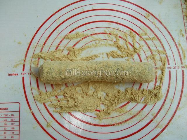 垫子撒上黄豆面 ，将卷好的糯米条在豆面上滚一圈，这个驴打滚就做好了。