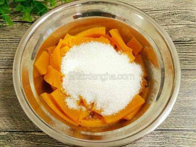 南瓜蒸熟后倒掉里面的水，趁热加入白糖搅拌成泥