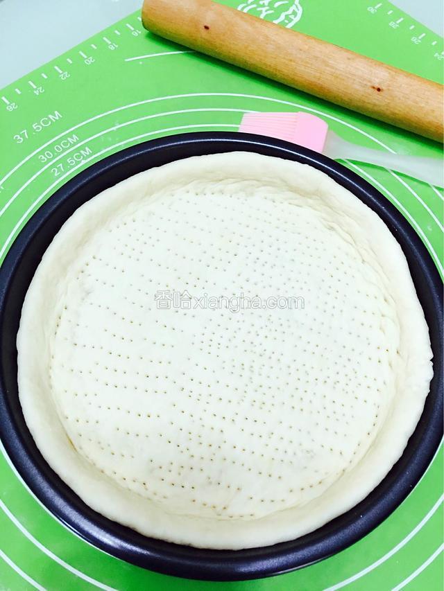 用擀面杖擀出10寸大，中间薄，周边稍微厚一点，用叉子在中间叉小孔排气，再放至5-8分钟。如图