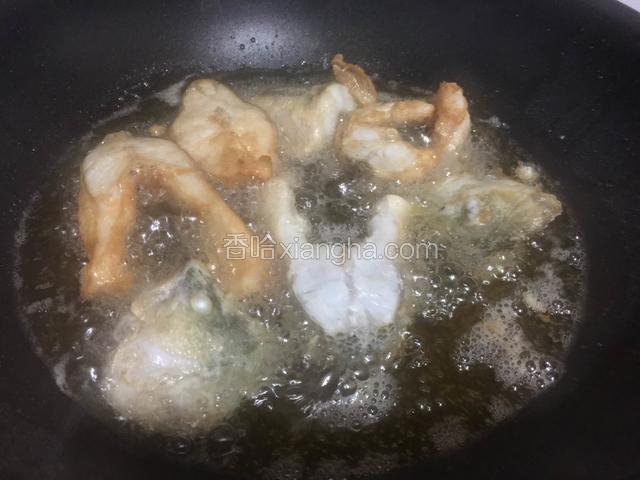 锅里倒入油烧至八九成热，放入鲈鱼用中小火炸